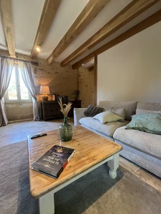 Espace détente avec canapé confortable et livre sur le Périgord pour votre séjour en Périgord Noir